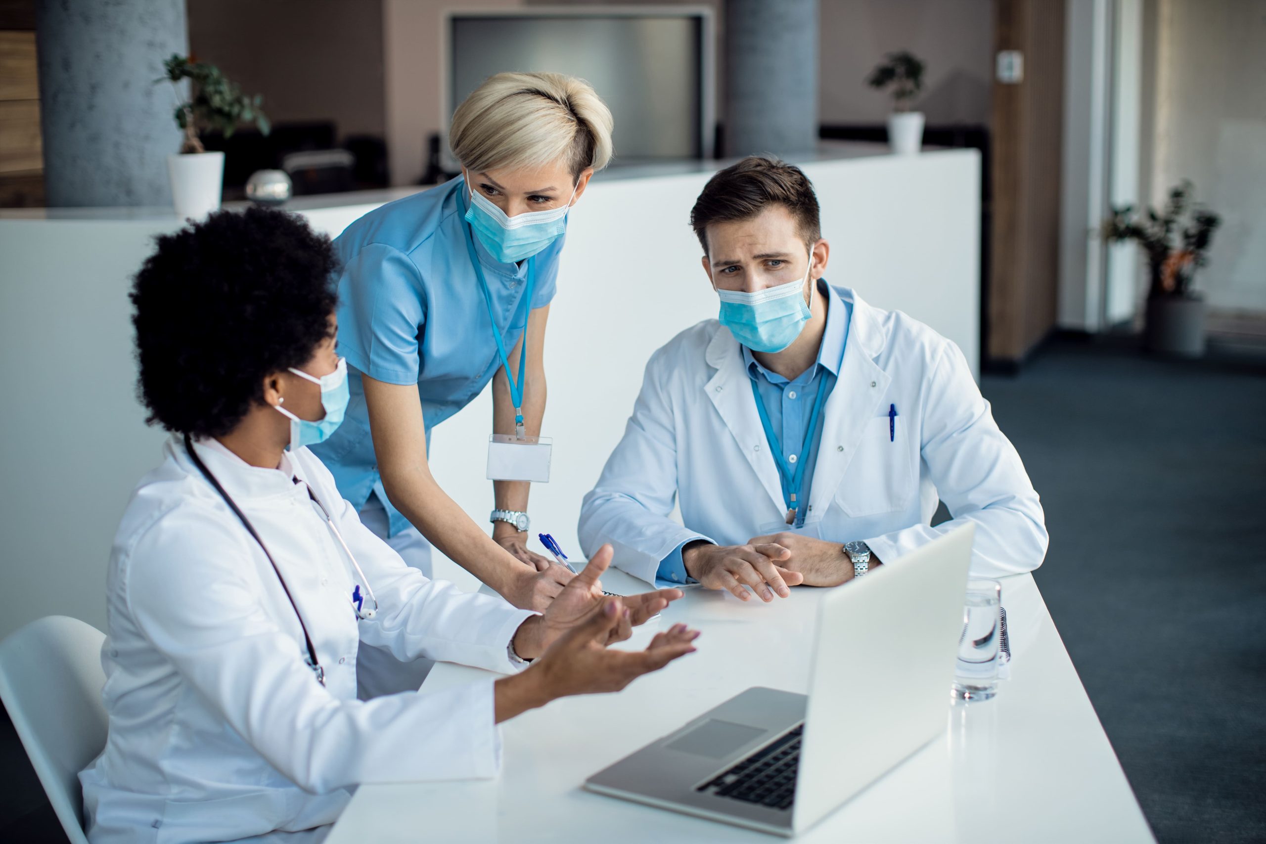 grupo expertos medicos hablando mientras usa computadora portatil reunion hospital 1 scaled